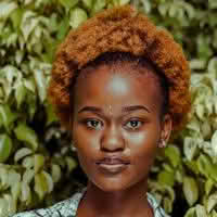 A woman named Olivia Ava with a stylish afro hairstyle, radiating confidence and charm