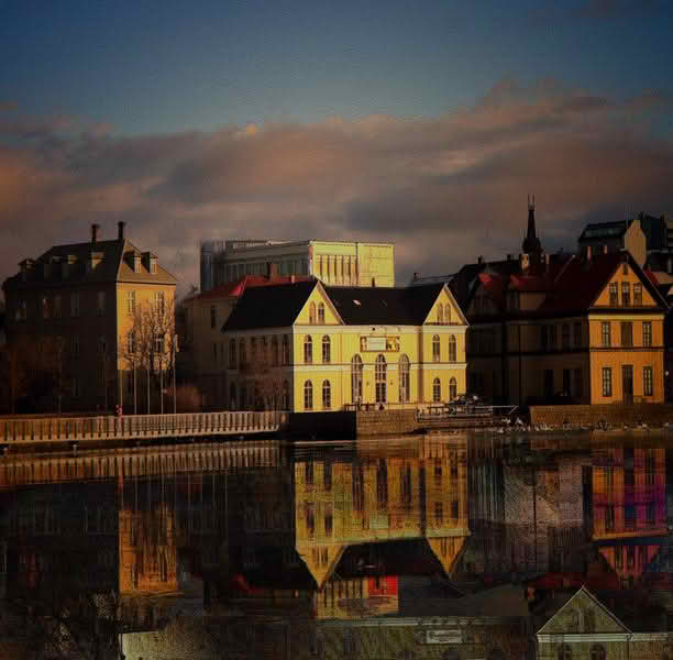 A panoramic view of a large body of water in Reykjavik, reflecting the city's skyline and surrounding landscapes